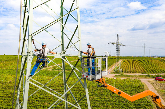 Moneteure arbeiten mit Hubsteiger an Strommast | © PWN