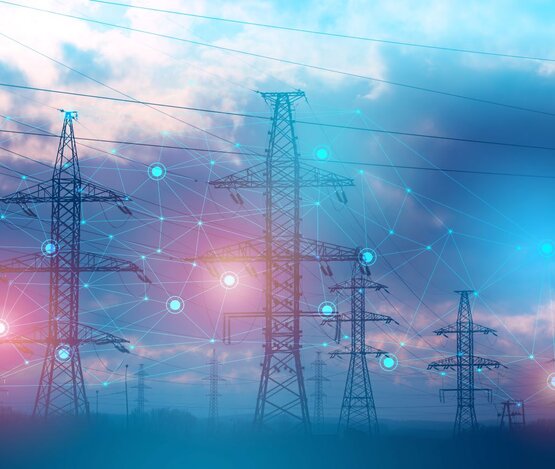 Mehrere Strommasten, an denen die Vernetzung durch Punkte und Netze dargestellt werden