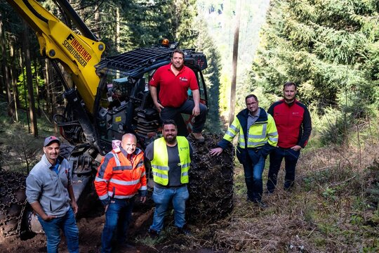 Mitarbeitende stehen vor dem Schreitbagger