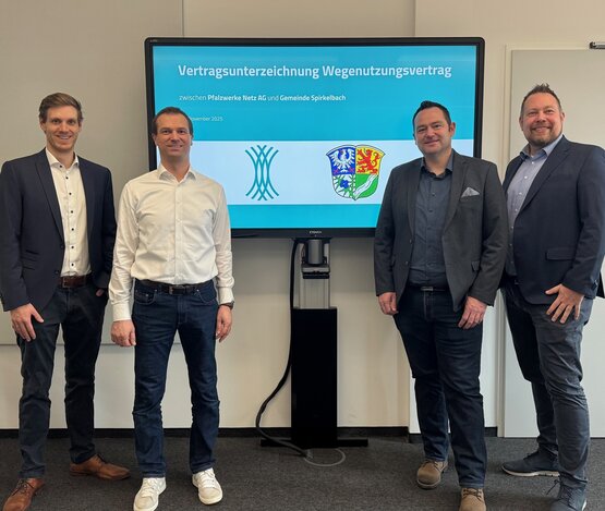 Gruppenbild von Ortsbürgermeister, Vorstand sowie Projektteam vor einem Monitor mit der Überschrft Vertragsunterzeichnung Wegenutzungsvertrag | © Pfalzwerke Netz AG